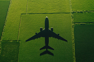 Airplane flying over green fields, a Photo by Beautiful things