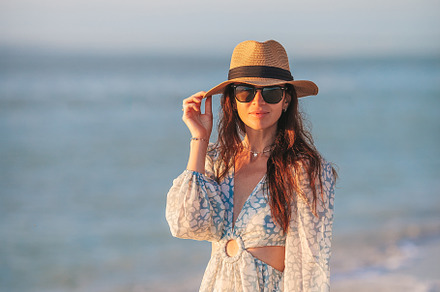 Young beautiful woman at straw hat on the beach at sunset, a Person Photo by travnikovstudio