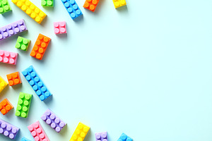 Colorful toy building blocks on pastel blue background. Baby educational game.