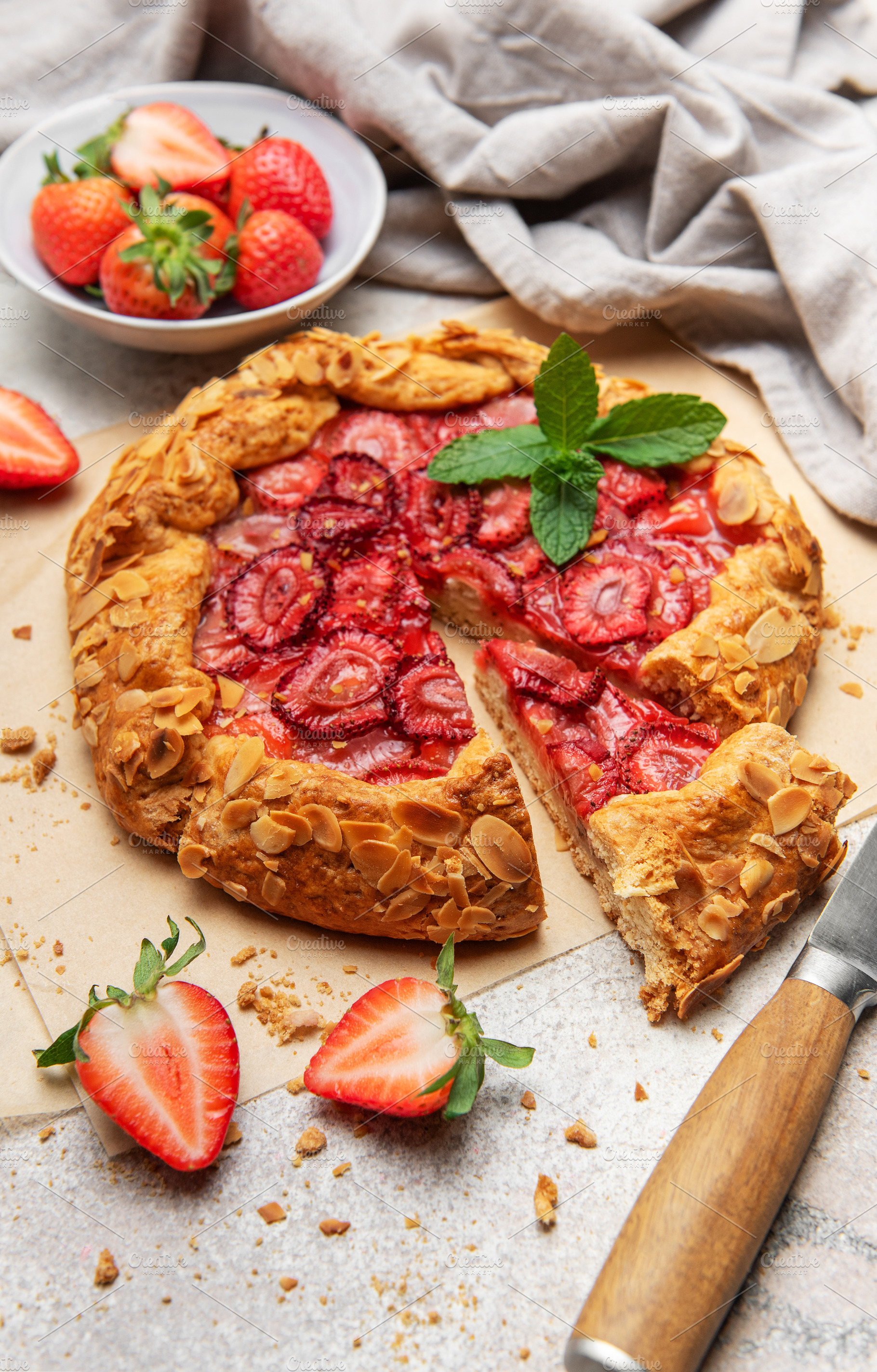Delicious homemade strawberry galette with almond petals baking, a Food & Drink Photo by Olena Rudo