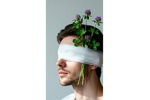 Man blindfolded with clover stems, a Person Photo by tilialucida