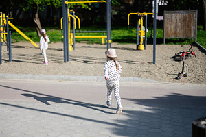 Young girl exploring a playground area with outdoors fitness equipment, a Person Photo by AS photostudio