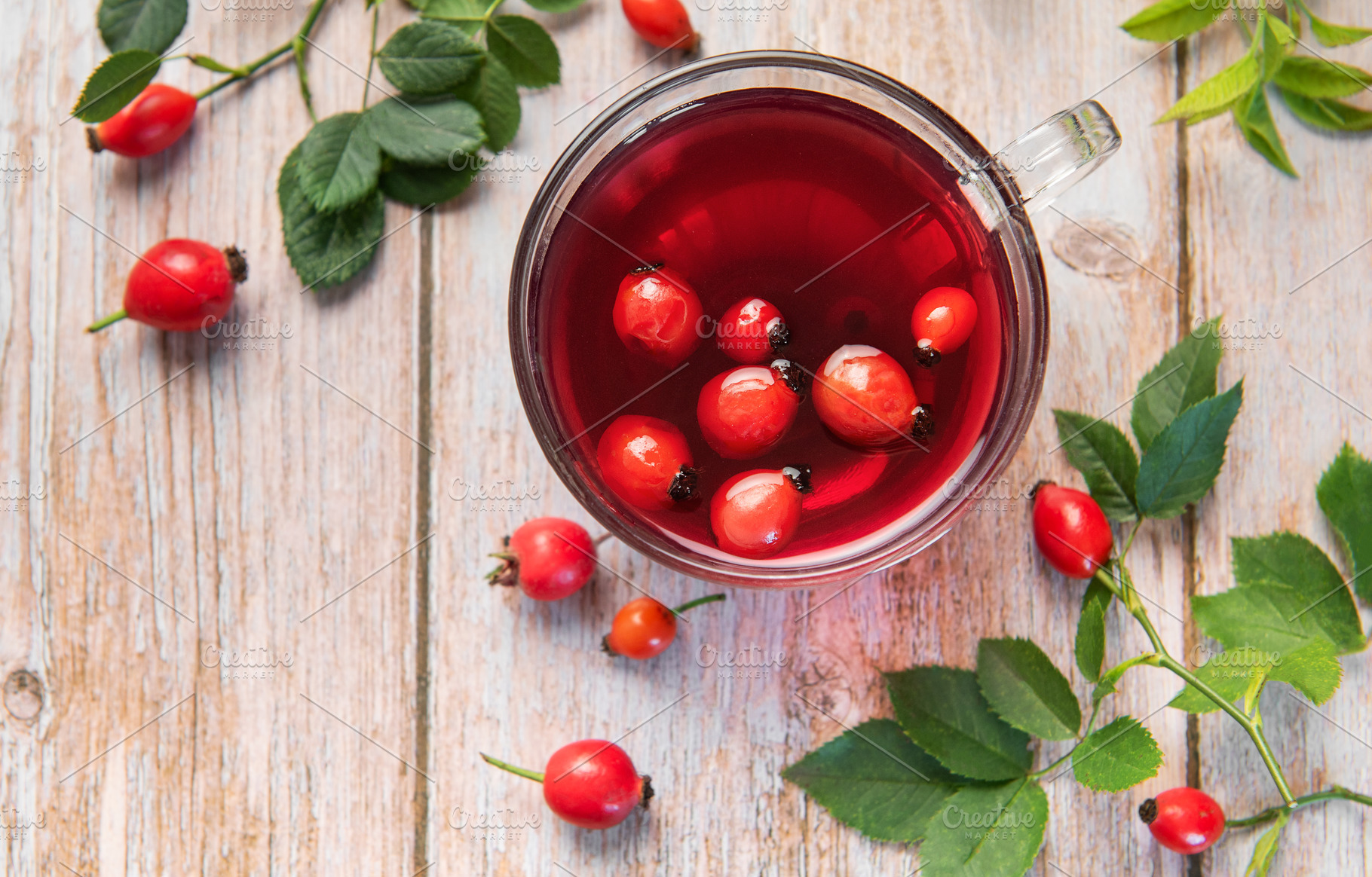 Rosehip tea brewing in glass cup on rustic wooden table, a Food & Drink Photo by Olena Rudo