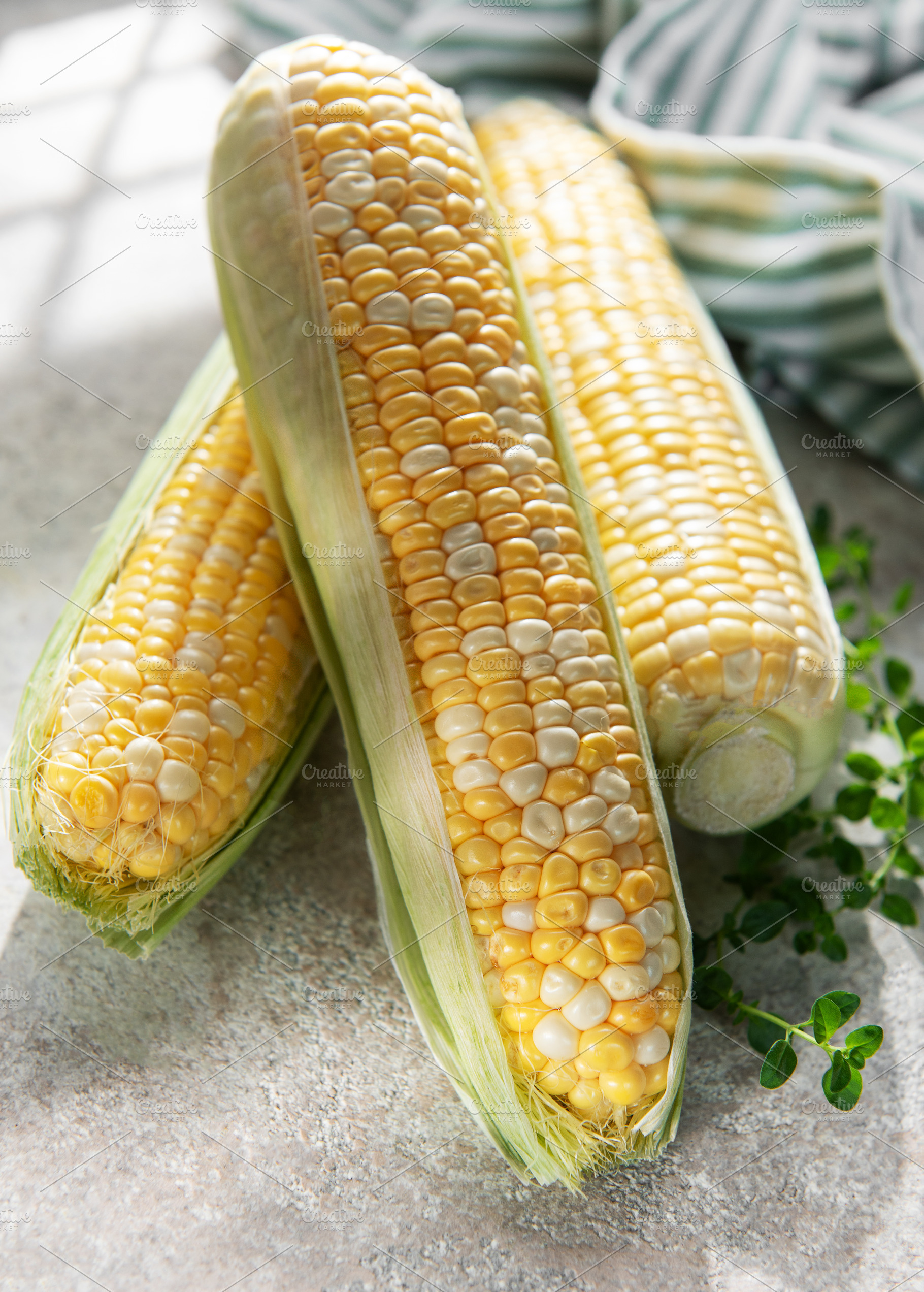 Fresh sweet corn cobs displaying yellow kernels, a Food & Drink Photo by Olena Rudo
