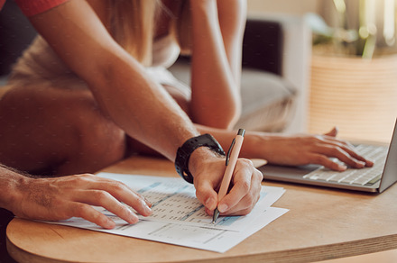Couple calculating budget, finance and tax while planning investment, loan and bills on writing paper and laptop at home. Managing household spending, savings and insurance report for online banking, a Photo by Peopleimages.com