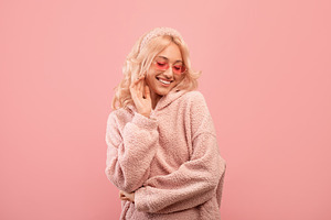 Pretty stylish lady looking down and smiling, wearing colorful sunglasses and h, a Photo by Prostock-Studio