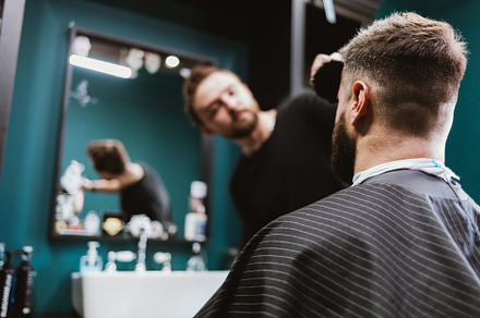 Young man during visit of barbershop sitting in chair, a Person Photo by progressman