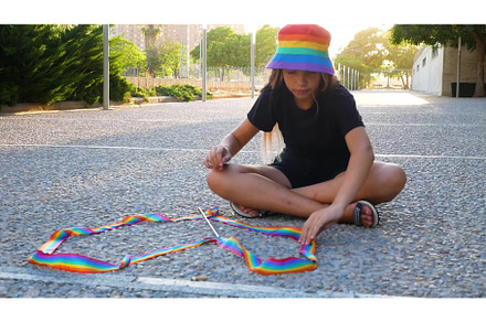 A young girl holds a rainbow lgbtq