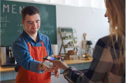 Cheerful young Down Syndrome waiter, a Person Photo by HalfPoint