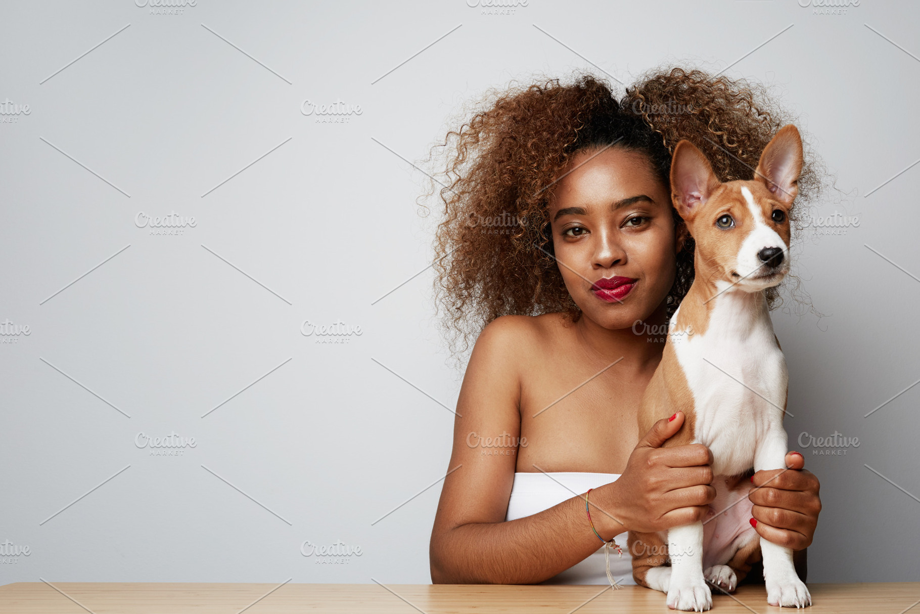 Young black african female with afro stock photo containing love and puppy, a Person Photo by Klever Level Studio
