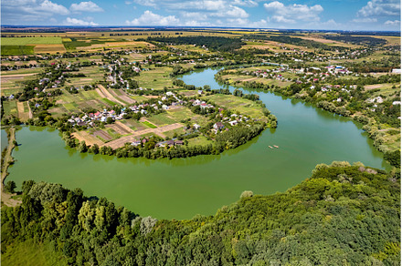 Aerial view of village surrounded by, a Nature Photo by Yaroslav Danylchenko