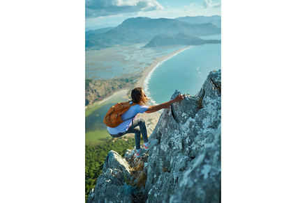 Active woman climbing up on cliff, a Person Photo by vitaliymateha photography