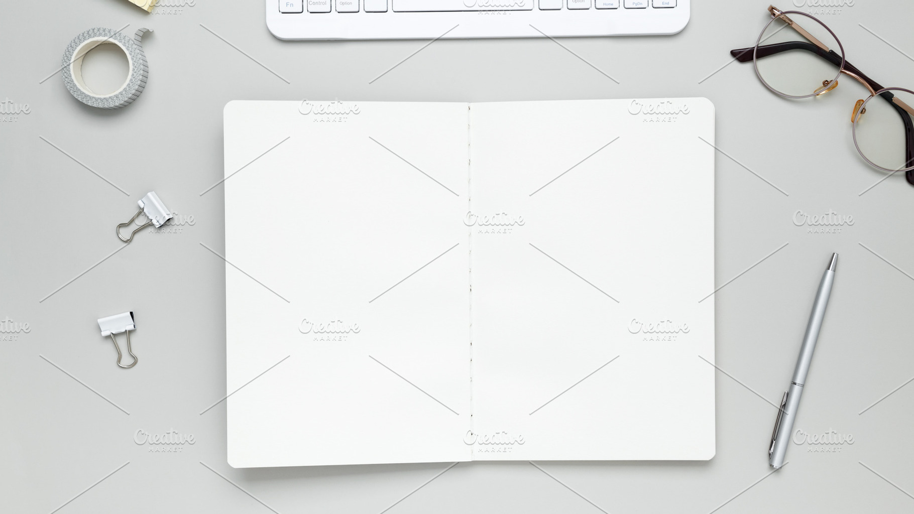Tidy workspace featuring stationery, keyboard, glasses, and notebook promoting, a Photo by matucha
