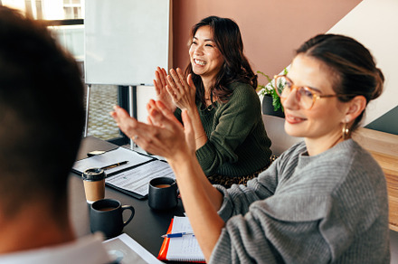 Happy businesspeople applauding during a meeting, a Person Photo by Jacob Lund