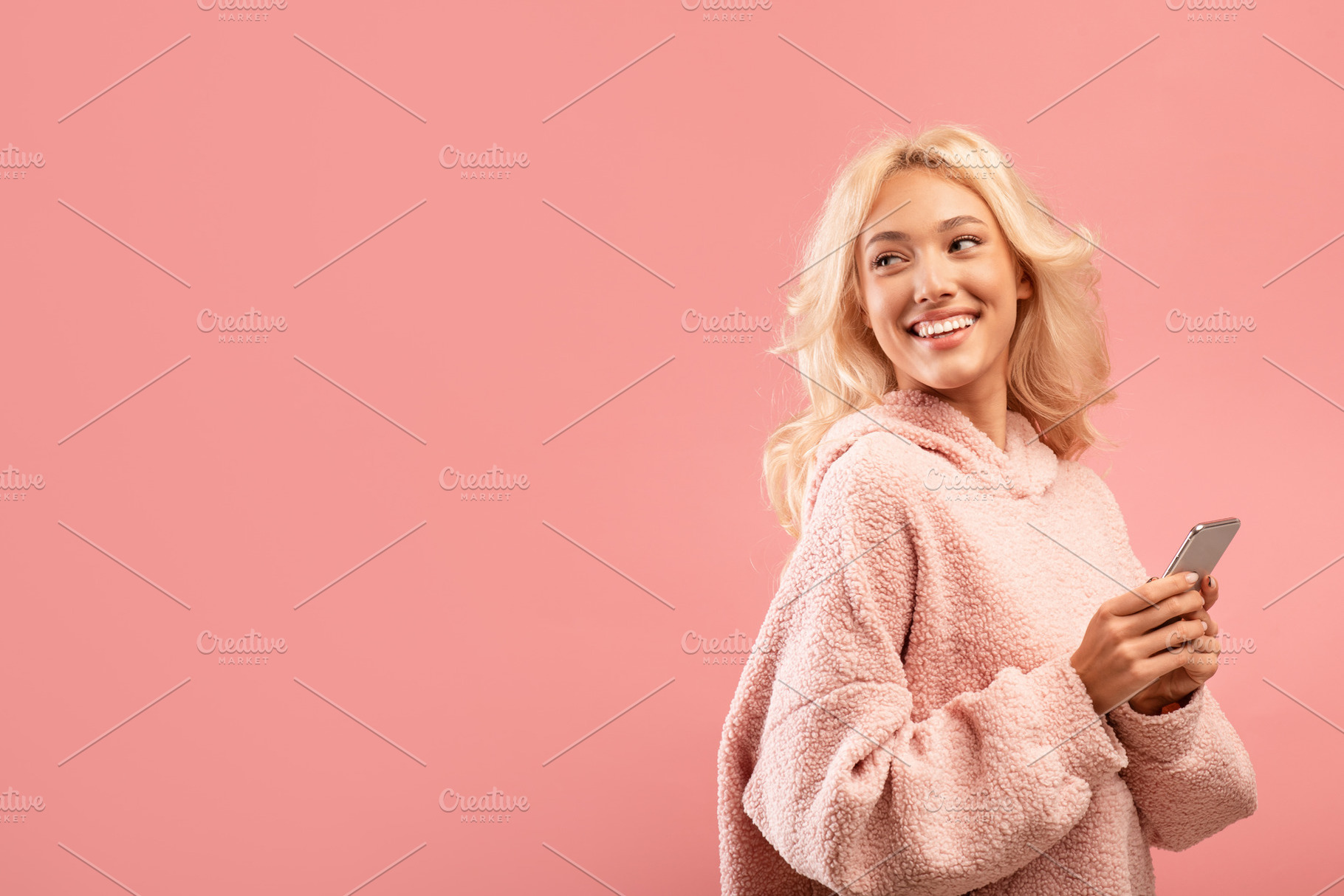 Happy caucasian lady with newest smartphone looking back at free space over pin, a Photo by Prostock-Studio