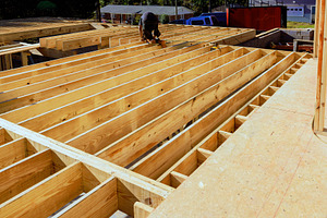 Construction worker installs wooden
