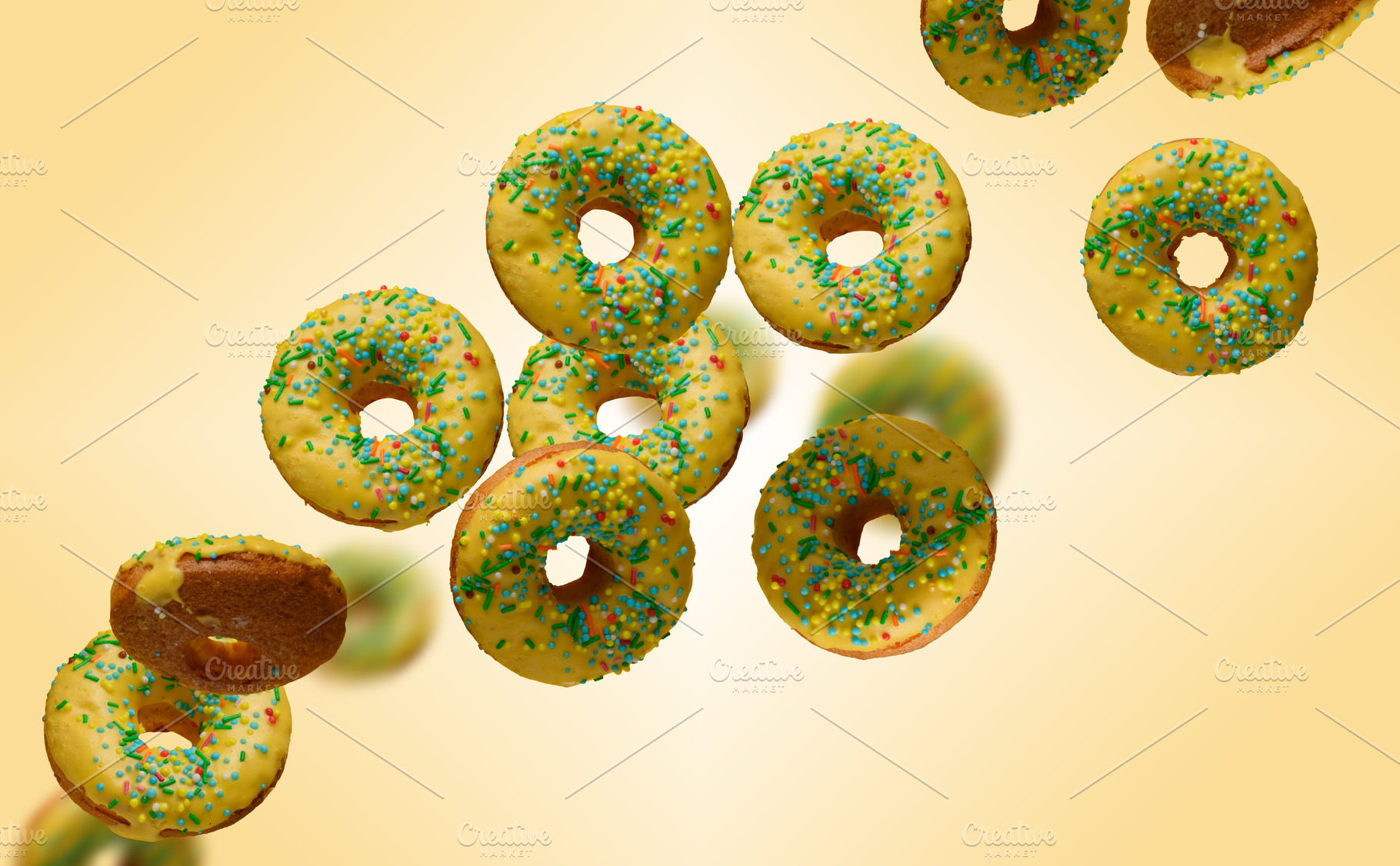 Yellow glazed donuts, each decorated with multi colored sprinkle, a Food & Drink Photo by ndanko