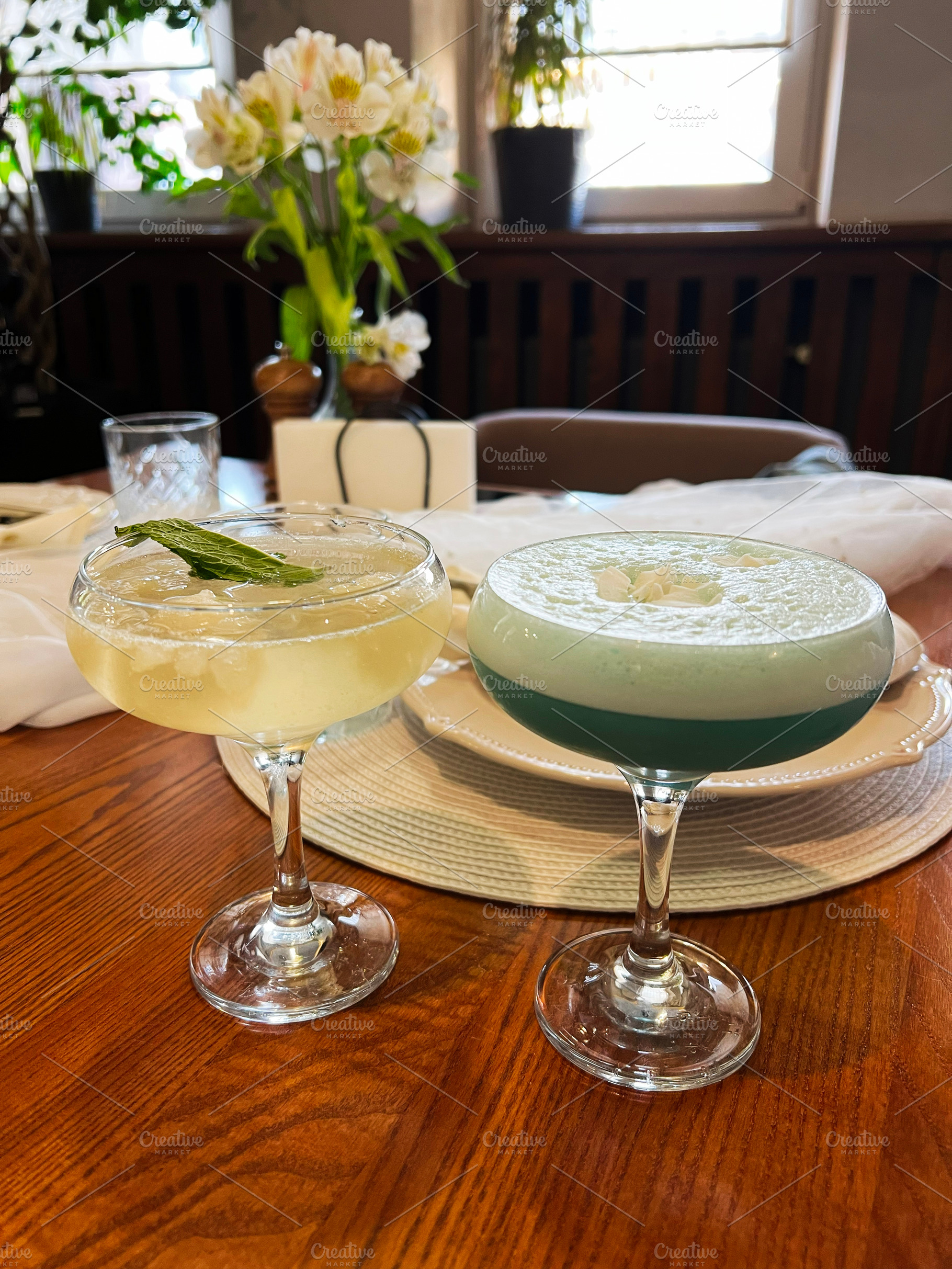 Elegant cocktails served in glasses on a wooden table with decorative elements, a Photo by AS photostudio