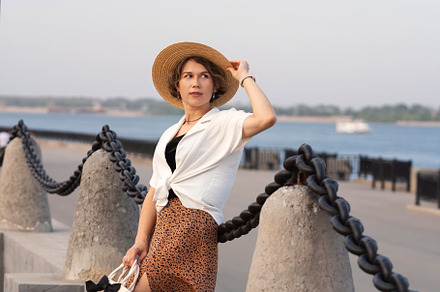 Woman adjusting straw hat