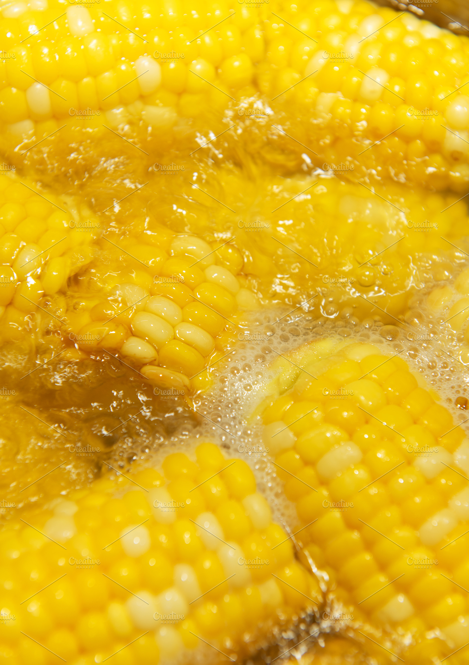 Fresh sweet corn cobs boiling in water, a Food & Drink Photo by Olena Rudo