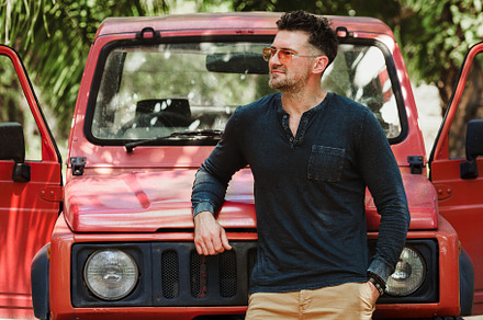 Attractive man and a red SUV. Closeup, outdoor