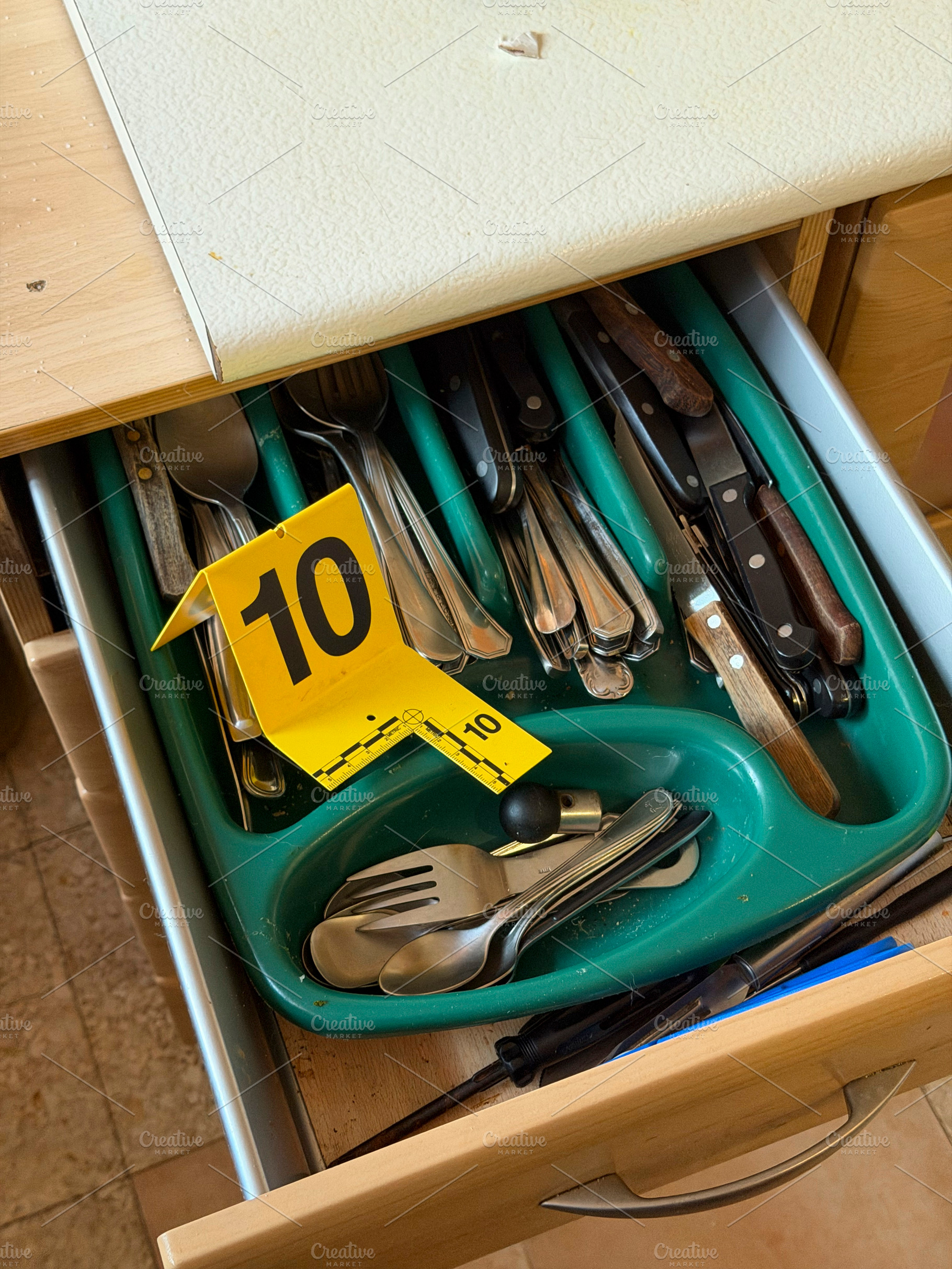 Evidence marker number 10 in kitchen cutlery drawer, an Industrial Photo by karrastock