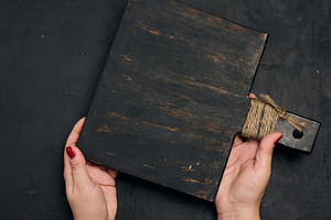A woman's hand holds the handle of an old, black wooden kitchen, a Person Photo by ndanko