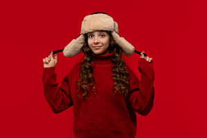 Smiling girl in fur hat holds ear, a Person Photo by Elena Vagengeim
