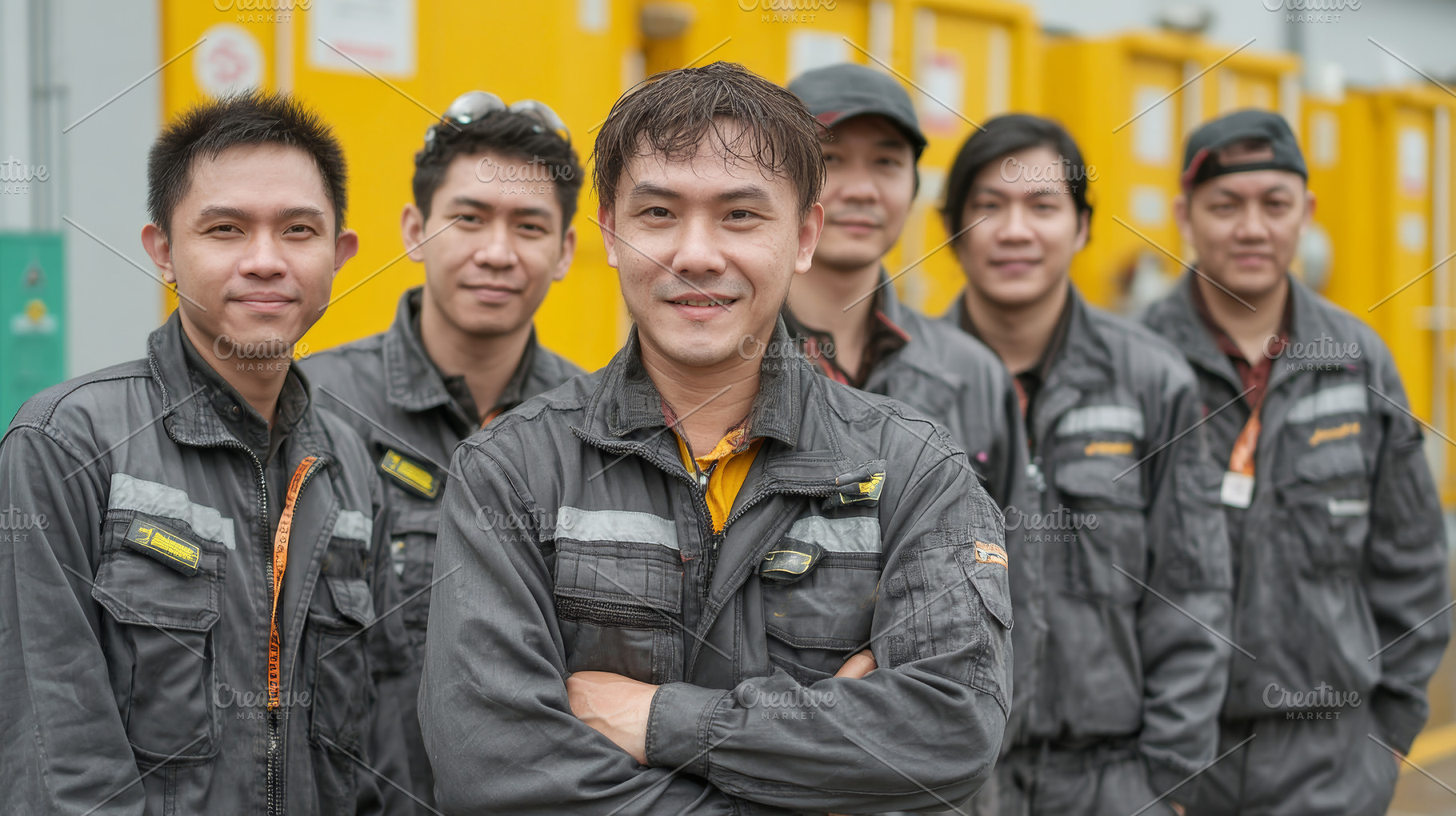 Team asian members in industrial uniforms standing together with a positive dem, an Industrial Photo by AS photostudio
