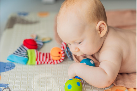 Adorable baby playing with colorful