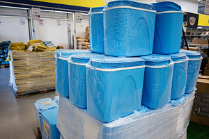 Blue storage containers displayed in a store aisle for retail purchase, a Photo by AS photostudio