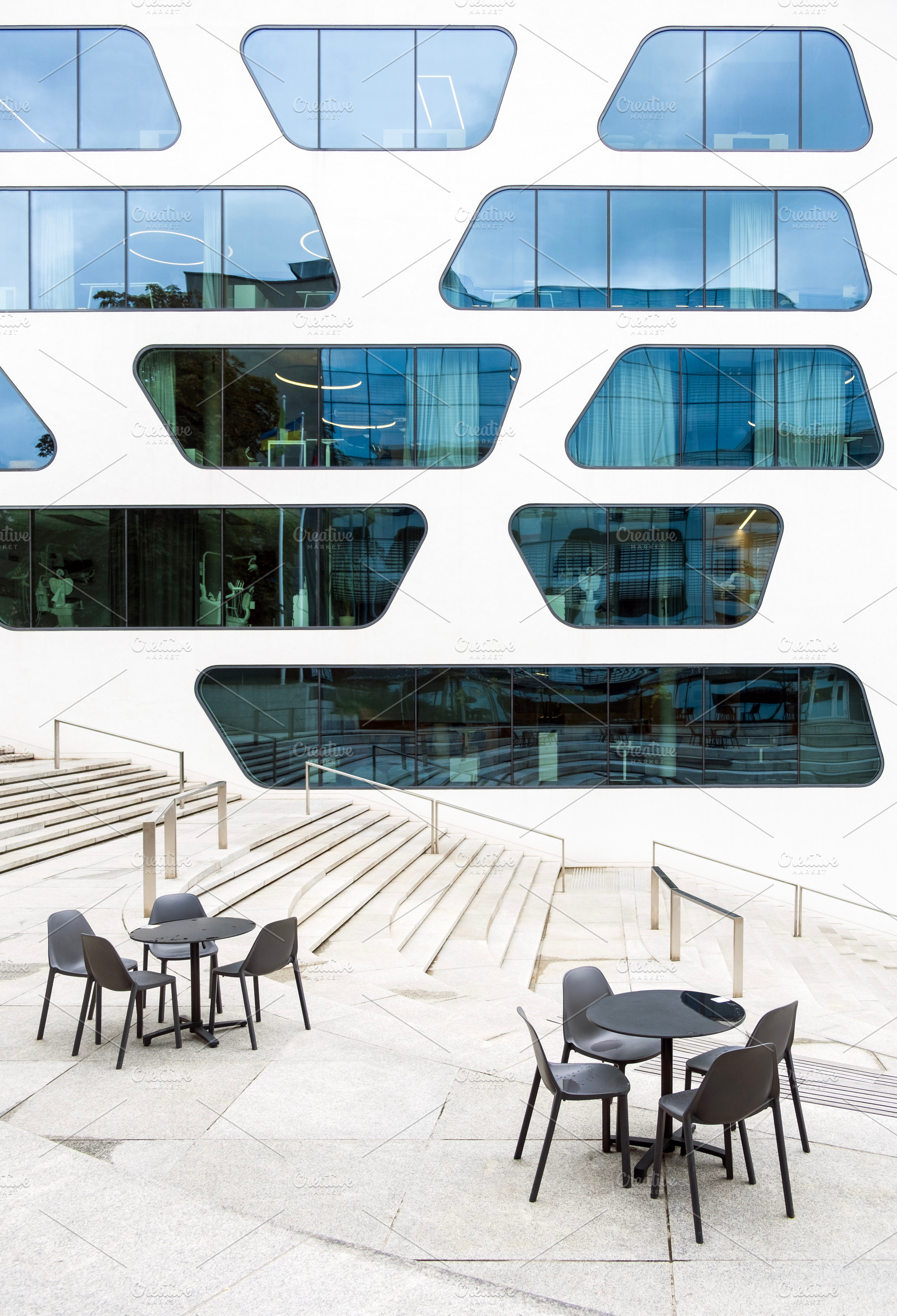Cafe tables and modern building, an Architecture Photo by BOOCYS