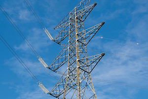Low-angle view of an electrical tower against a blue sky, an Industrial Photo by DanFLCreativo