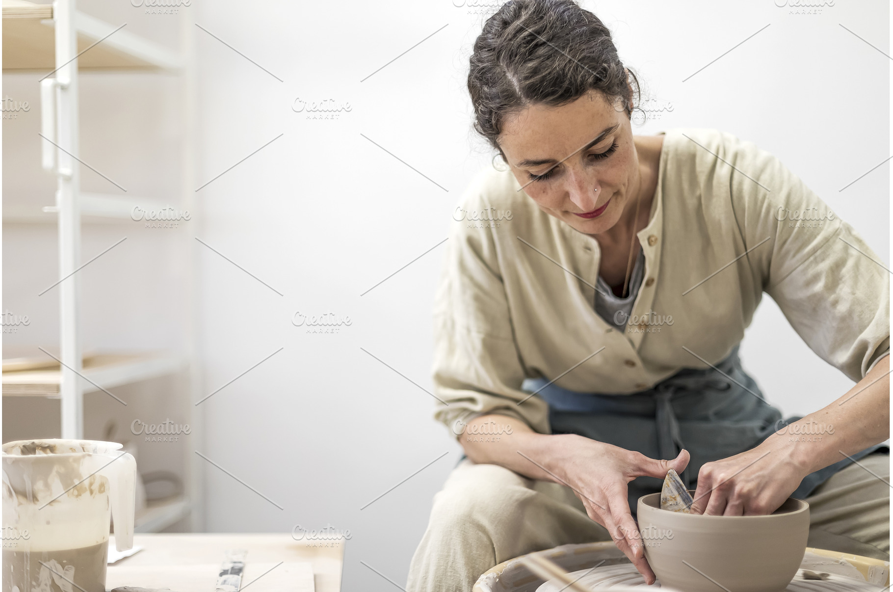 Lady siting on bench with pottery, a Business Photo by 2Design