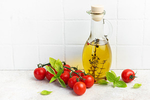 Olive oil bottle with fresh cherry tomatoes basil, a Food & Drink Photo by Olena Rudo