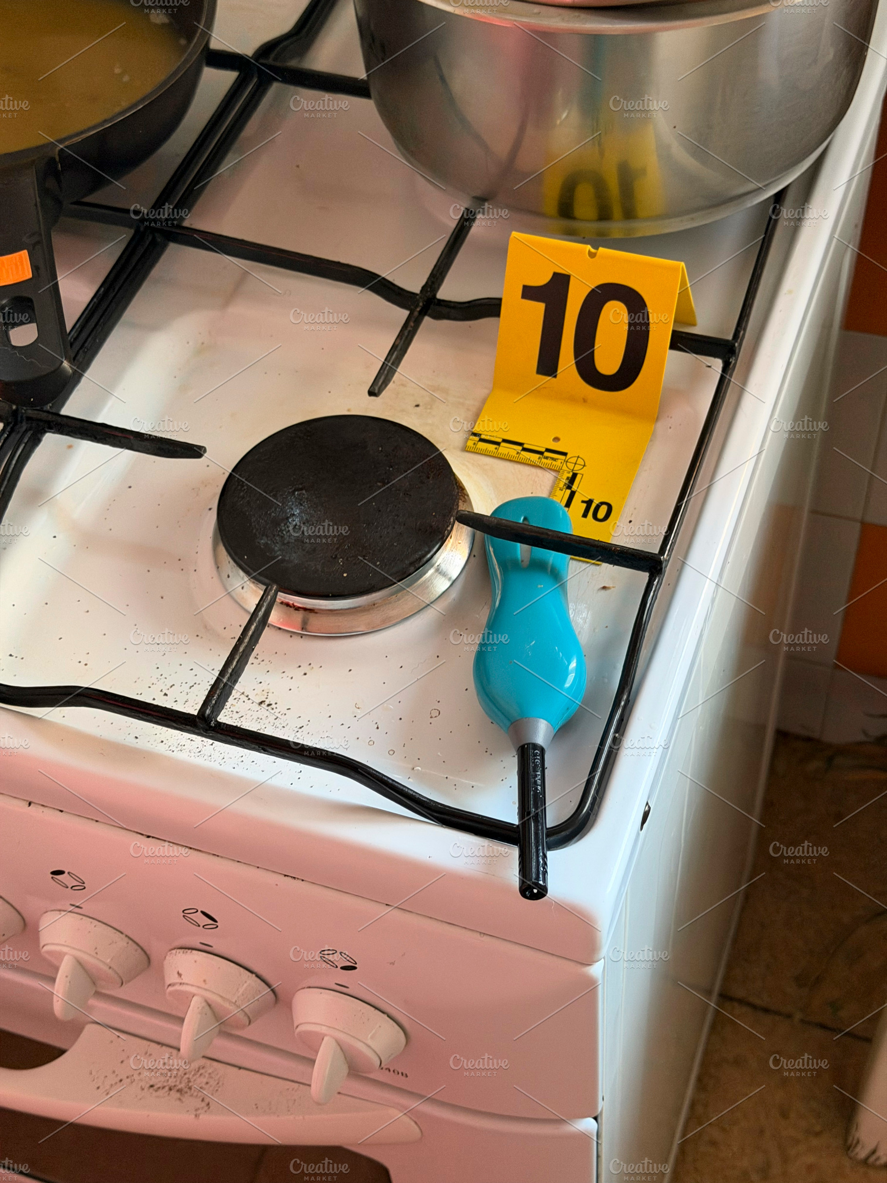 Forensic investigation marking evidence on kitchen gas stove, an Industrial Photo by karrastock