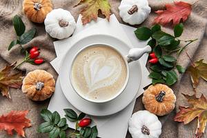 Autumn latte art heart with fall pumpkins and leaves