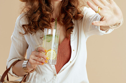 smiling woman in blouse and shorts against beige, a Person Photo by Alliance Images