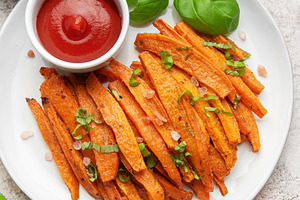 Sweet potato fries with ketchup and fresh basil, a Food & Drink Photo by Olena Rudo