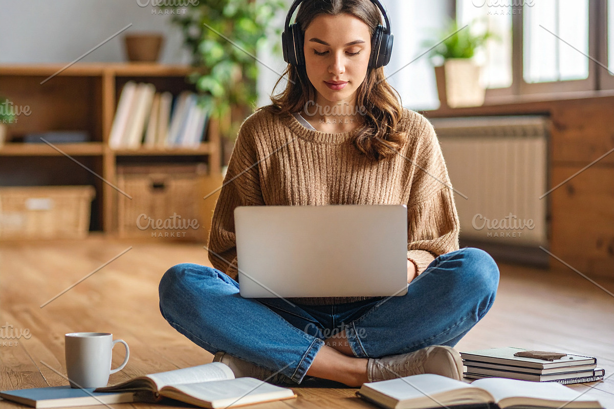Student on the floor surrounded by notebooks, headphones, coffee, a School & Education Photo by DanFLCreativo (Photo 2 of 2)