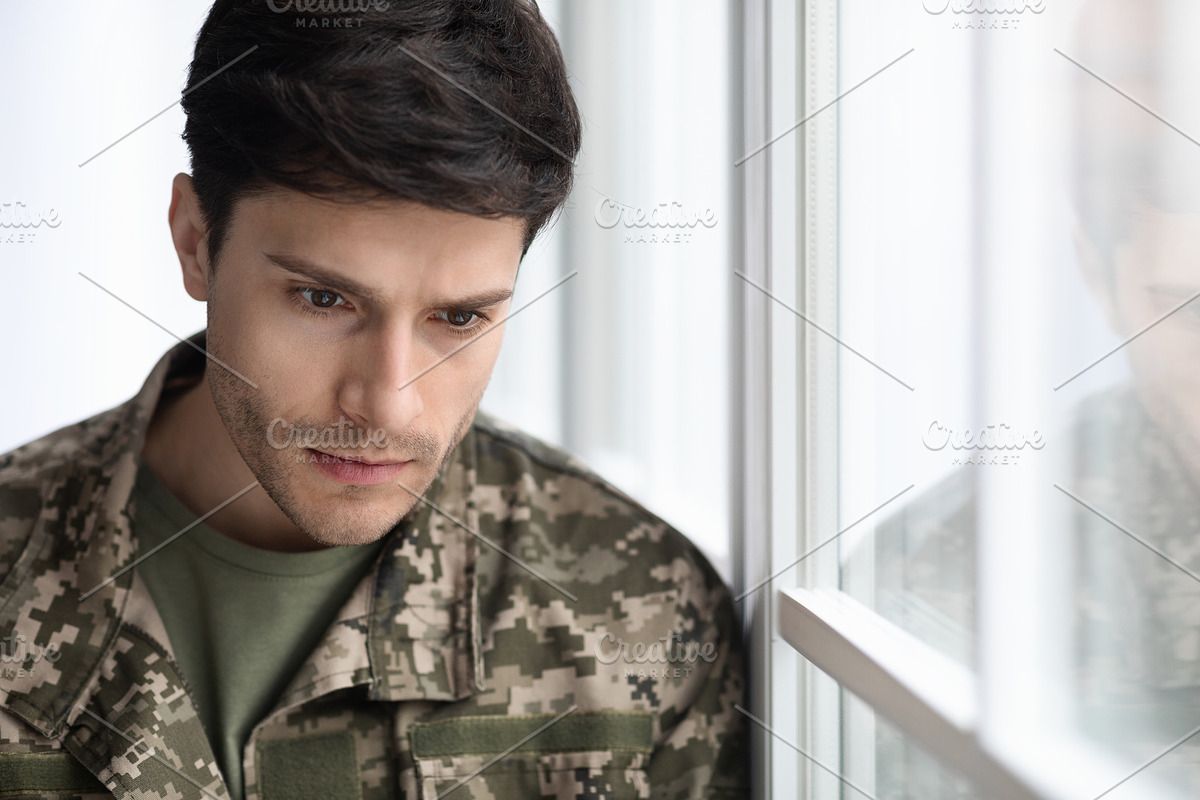 depressed military guy standing next to window, closeup, a Photo by Prostock-Studio (Photo 1 of 3)