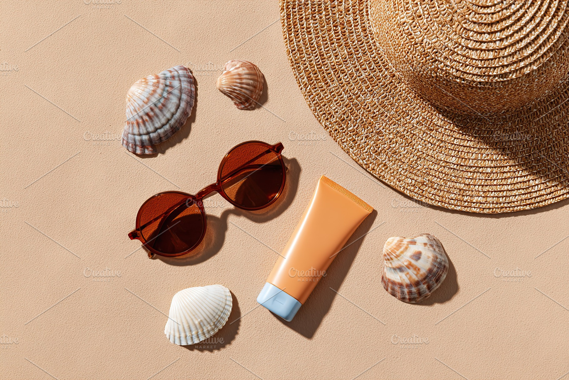 Summer beach essentials arranged on warm sand with seashells and accessories, a Beauty & Fashion Photo by AlyaAnd