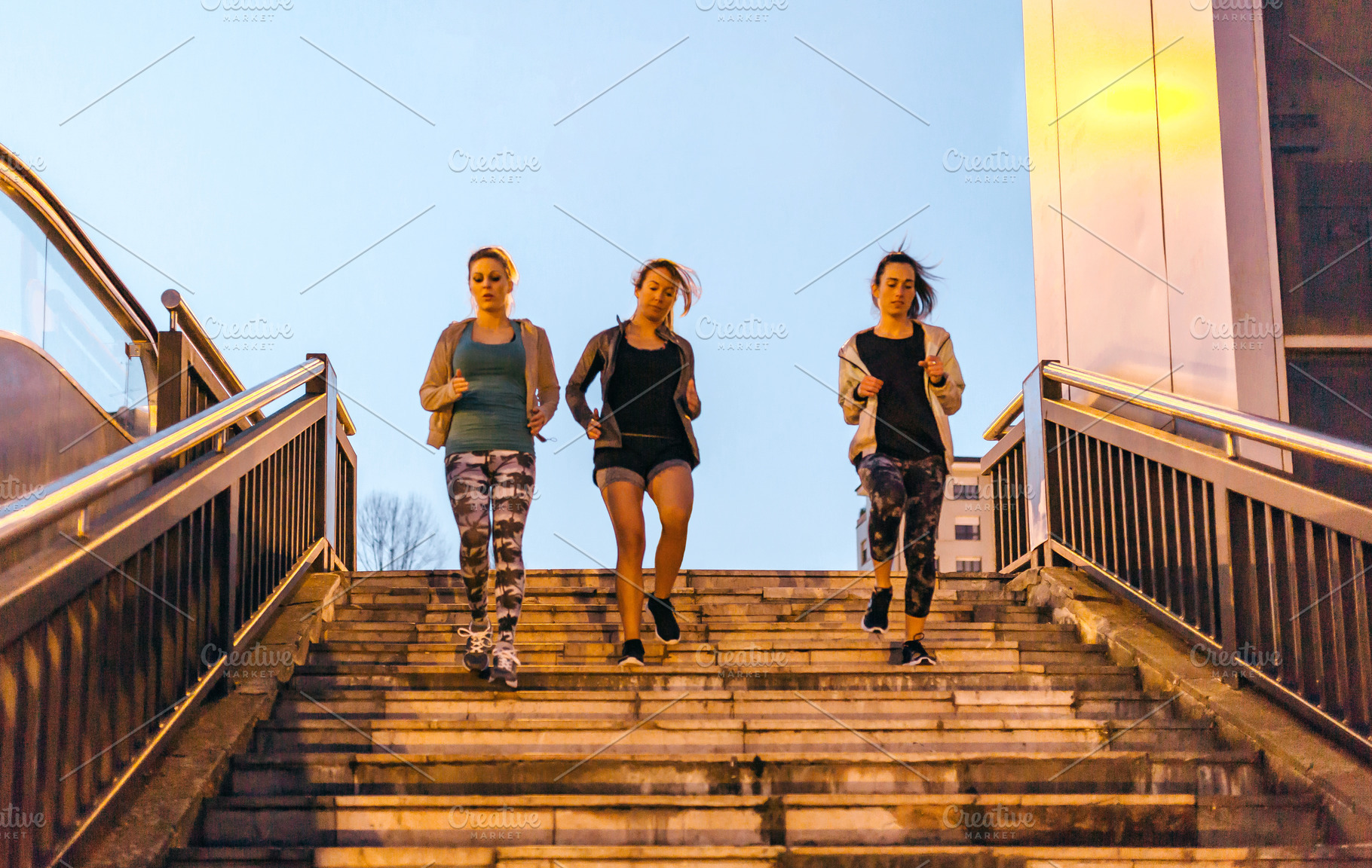 Women friends training running down stairs in town on sunset, a Sports & Recreation Photo by davidpereiras