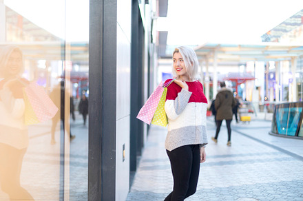 Smiling woman shopping with colorful bags in a modern mall., a Photo by RF Images
