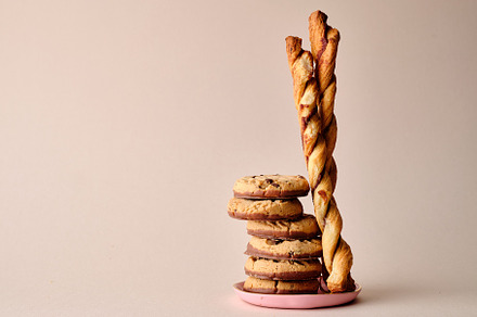 A stack of chocolate-covered biscuits and cookie sticks on beige