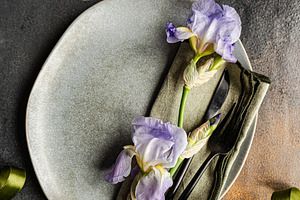 Table setting with pale blue iris flowers, a Food & Drink Photo by Anna Bogush