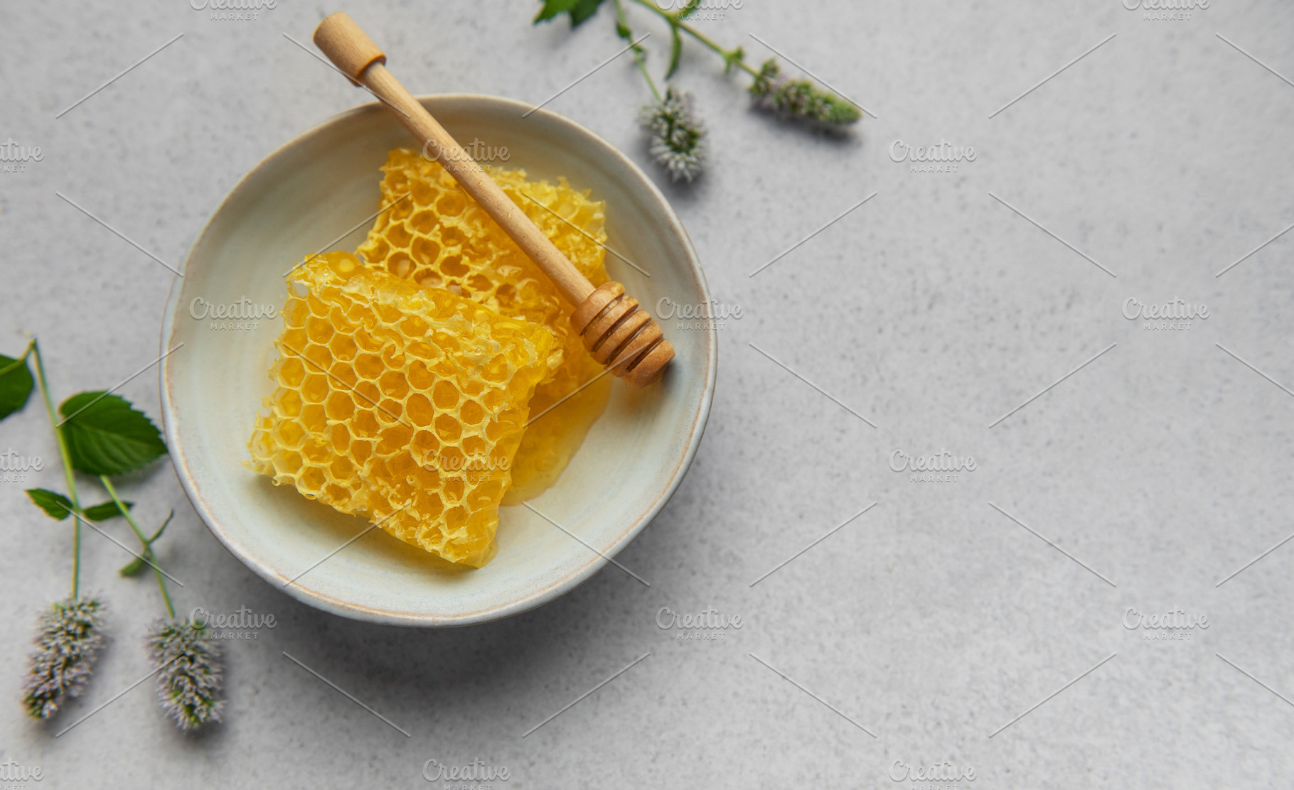 Honeycomb, honey dipper and fresh mint resting on a ceramic bowl, a Food & Drink Photo by Olena Rudo