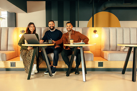 Happy businesspeople working in a modern lobby, a Person Photo by Jacob Lund