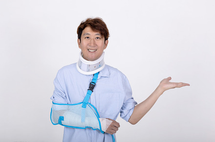 Smiling Asian man with broken arm and neck showing empty space i