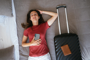 Woman lying on a hotel bed with a